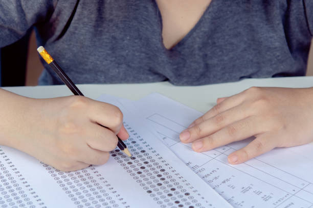 istock Students hand holding pencil writing selected choice on answer sheets and Mathematics question sheets. students testing doing examination. school exam 1746877126