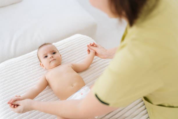 istock View from shoulder of unrecognizable pediatric masseur with cute baby boy doing exercise simple exercises to make baby bones and muscles stronger. 1746885654