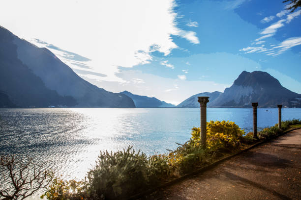 Fantatsic  view on  lake Lugano and  park of Helenium villa (free of charge) ,  columns  in park . Swiss Alps and mount San Salvatore. Railroad Bridge through lake Lugano- is barely visible.