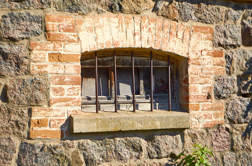 Window with bars of the ancient storage of the mill in Dashev