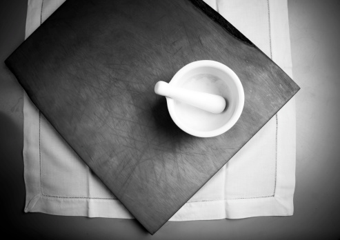 Mortar pestle on chopping board black white. Artistic vignetting has been used.See ‘Food and Entertaining’ collection: