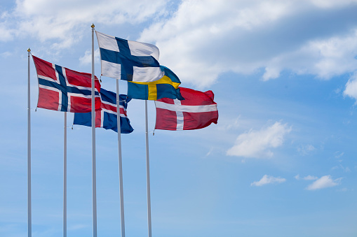 The flags of the Nordic Countries waving in the wind.