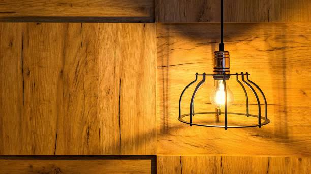 istock Wooden wall with shining lamp on top. 1746904976
