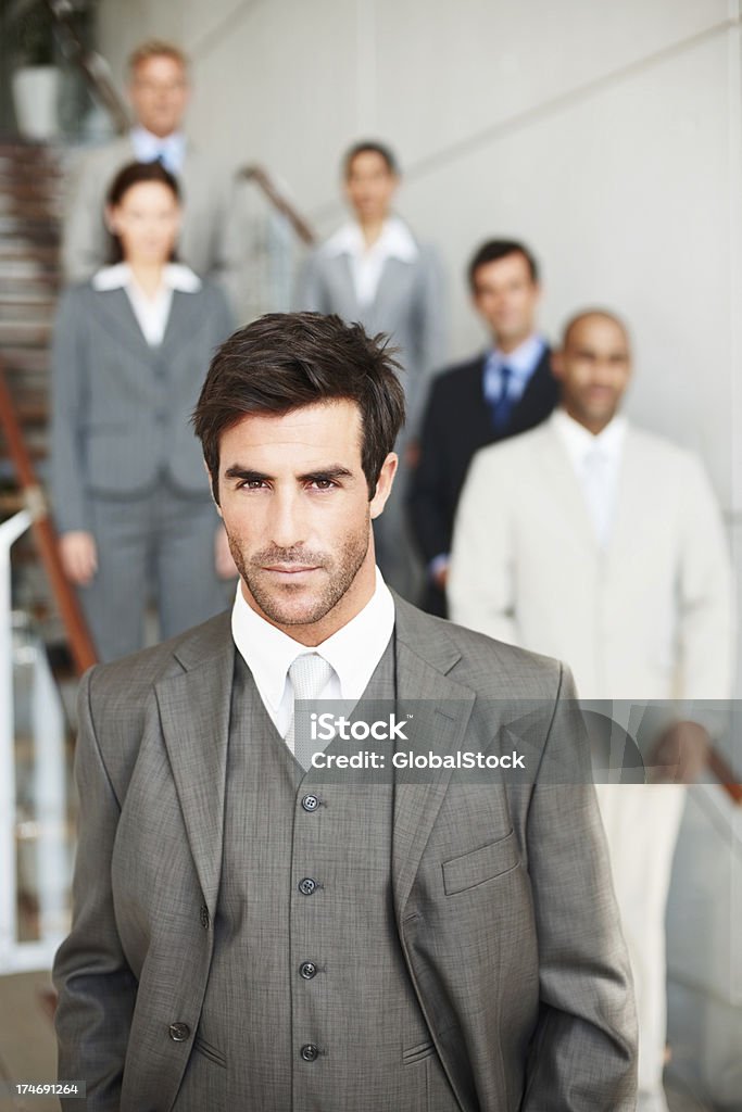 Seguros de hombre de negocios con colegas en fondo - Foto de stock de 20 a 29 años libre de derechos