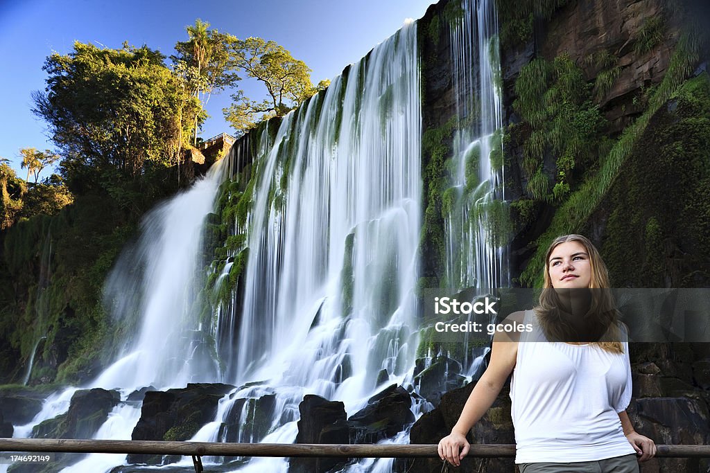 Beauty and Nature "A beautiful young woman - a tourist - stands amongst one of the many falls found in Parque Nacional Iguazu, Argentina.Please check out the following lightboxes if you would like to see additional similar photos:" 20-24 Years Stock Photo