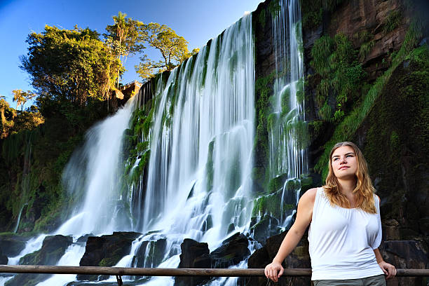 Beauty and Nature "A beautiful young woman - a tourist - stands amongst one of the many falls found in Parque Nacional Iguazu, Argentina.Please check out the following lightboxes if you would like to see additional similar photos:" misiones province stock pictures, royalty-free photos & images