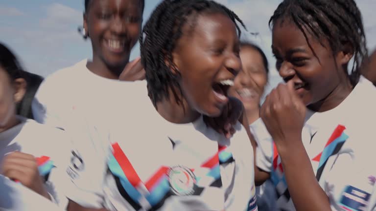 Teenage girls soccer team running together on a sports field