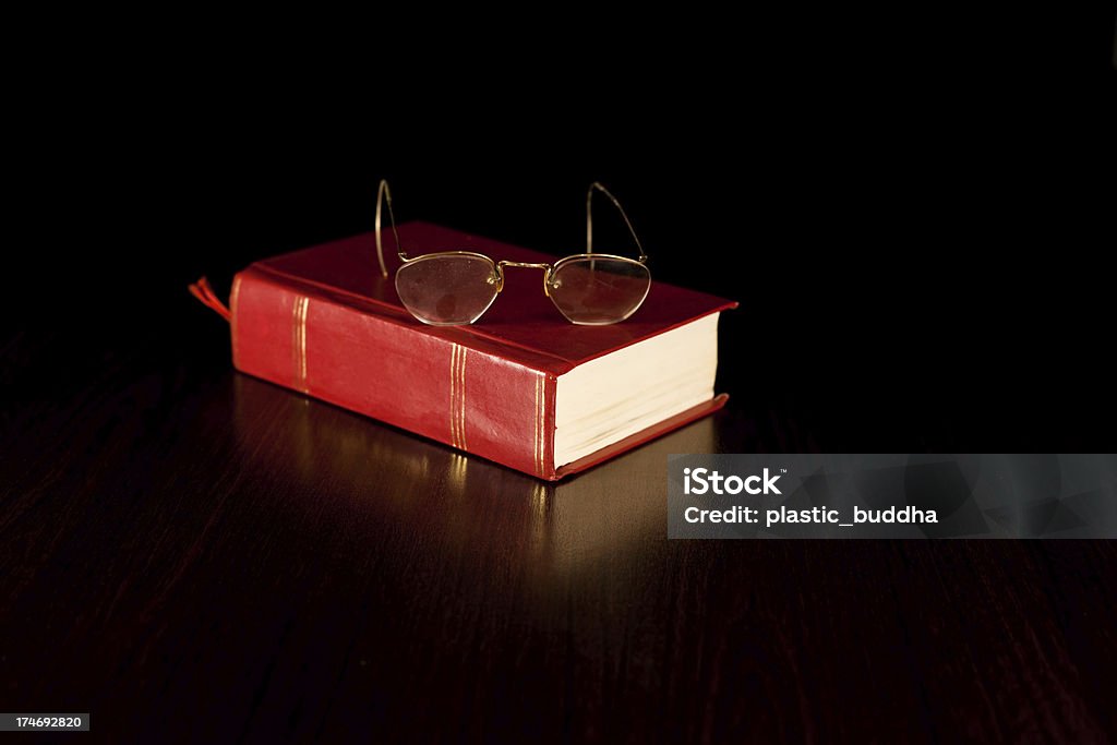 book and glasses old eye glasses on a thick book  note: dust on glasses left on purpose Book Stock Photo