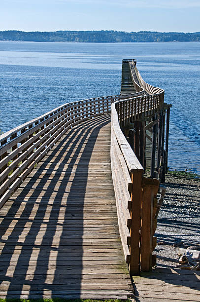 pier mit leichten curve in washington state - puget sund stock-fotos und bilder