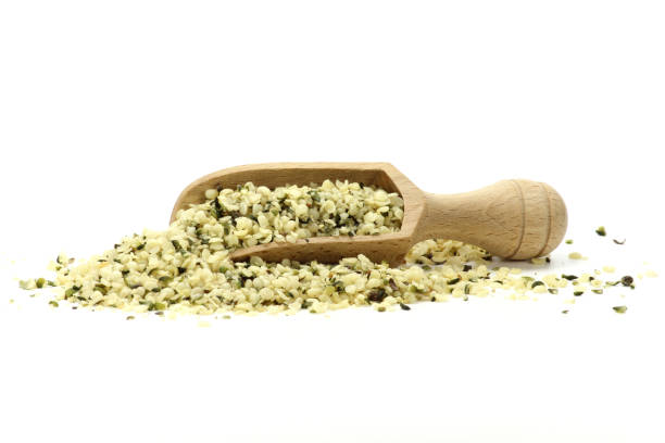 wooden scoop with peeled hemp seeds isolated on white background