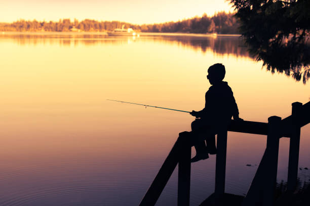 istock Boy fishing at sunset. 1746934058