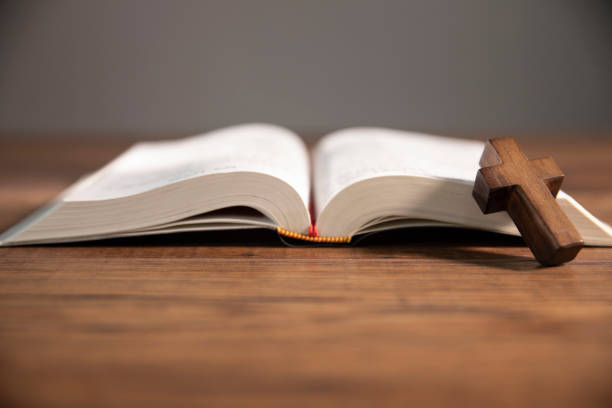 istock cross on open bible wooden table 1746936817
