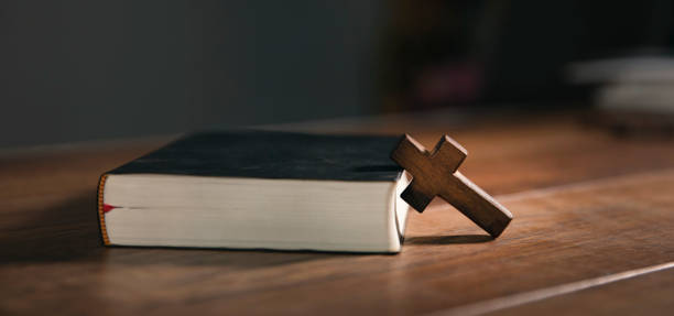istock cross on open bible wooden table 1746936818