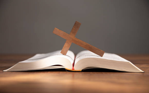 istock cross on open bible wooden table 1746936823