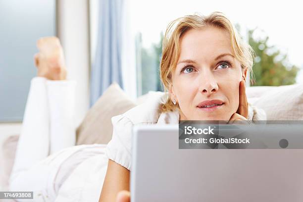 Mitte Erwachsene Frau Mit Einem Laptop Und Denken Stockfoto und mehr Bilder von E-Mail - E-Mail, Traumhaft, Wachsamkeit