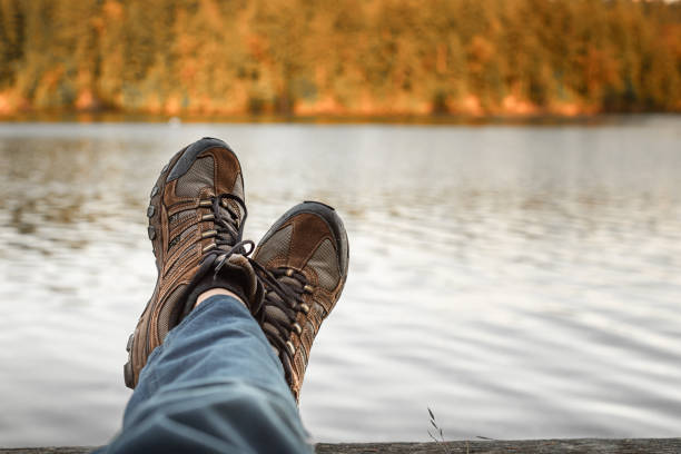 Point view of unrecognizable woman, and her hiking boot while traveling and exploring nature
