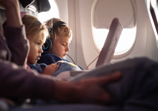 istock Boy and girl using a digital tablet during the flight. 1746938528