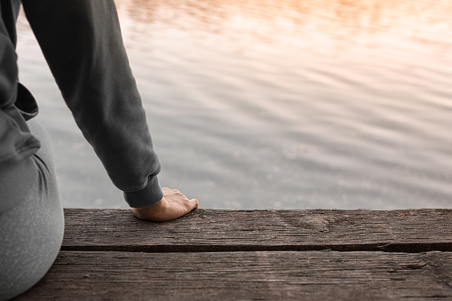 Woman sitting by the lake and enjoying beautiful view.