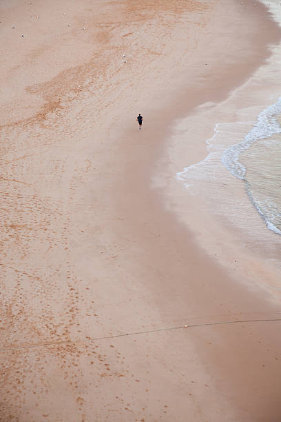 istock XXXL Lone runner in empty beach 174694777