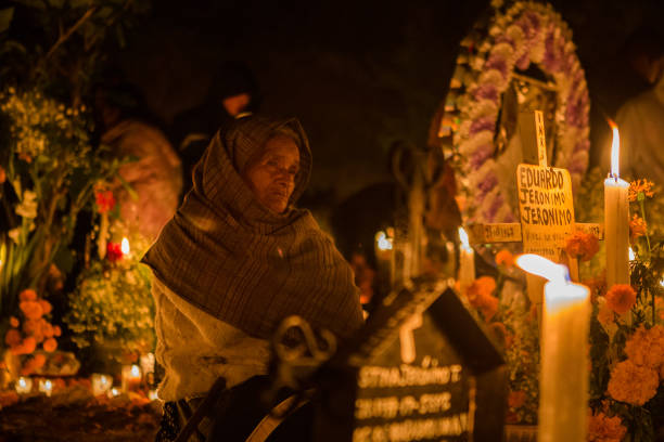 Woman spends the night at the cemetery of Arocutin, Michoacan State (Mexico)  during celebration of the Day of the Dead.