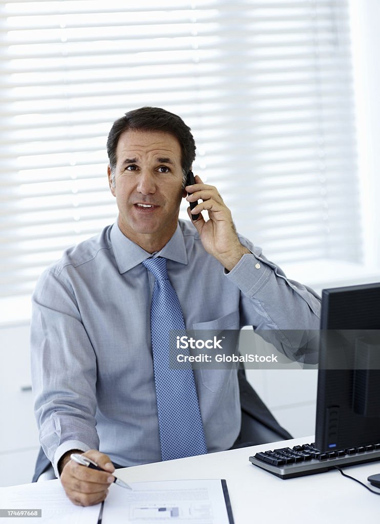 Empresário falando no celular no escritório - Foto de stock de 40-44 anos royalty-free
