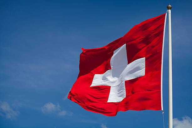 Switzerland's national flag flying Swiss flag waving in the wind. swiss flag photos stock pictures, royalty-free photos & images