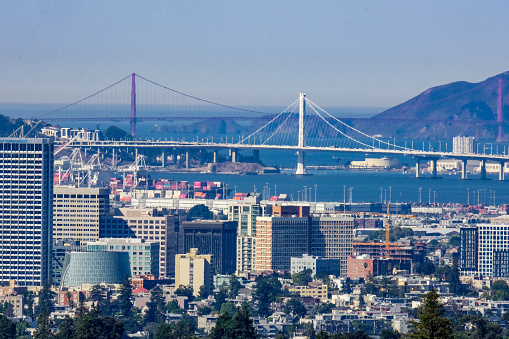Picture of Oakland Downtown with Bay Bridge and Golden Gate Bridge in the background, taken from Oakland Hills.
