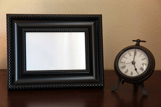 Empty picture frame and clock. stock photo