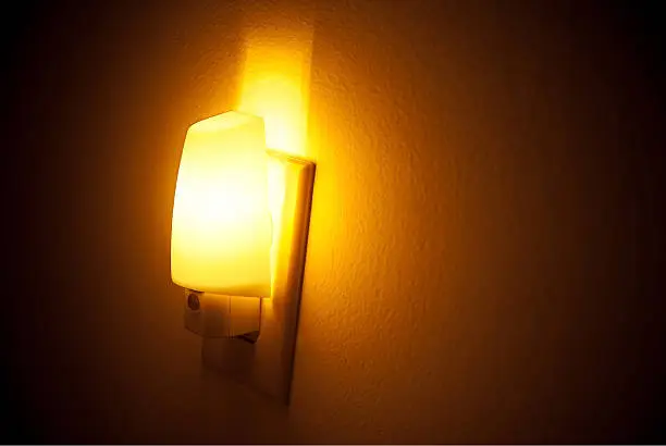Image of a night light providing visibility in a dark hallway.