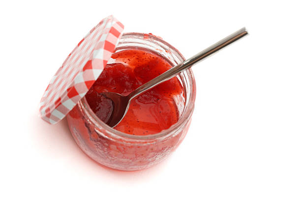 Strawberry Jam A jar of homemade strawberry jam on white background jam stock pictures, royalty-free photos & images