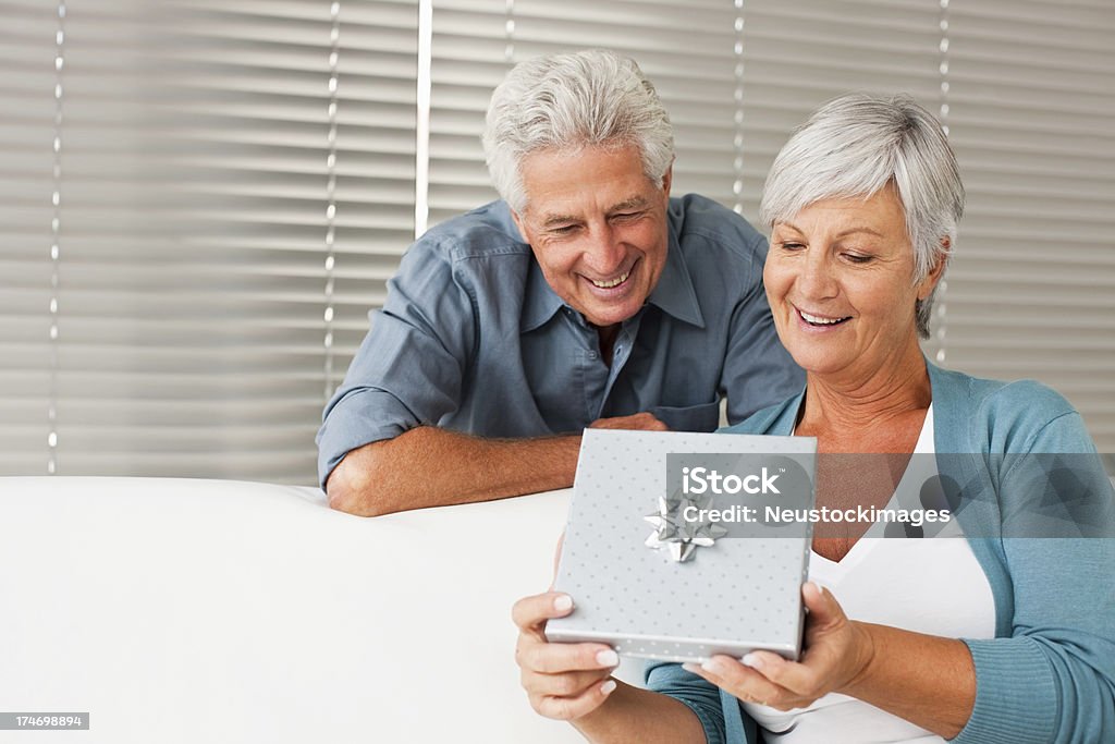 Senior uomo gifting Amorevole moglie - Foto stock royalty-free di 60-64 anni