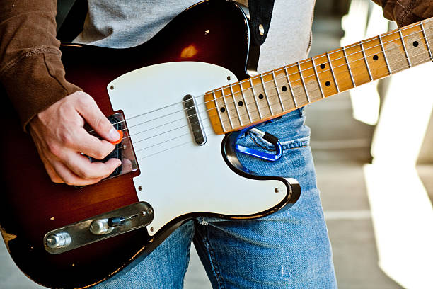 The Southeast Asian girl praticing electric guitar from smart phone.