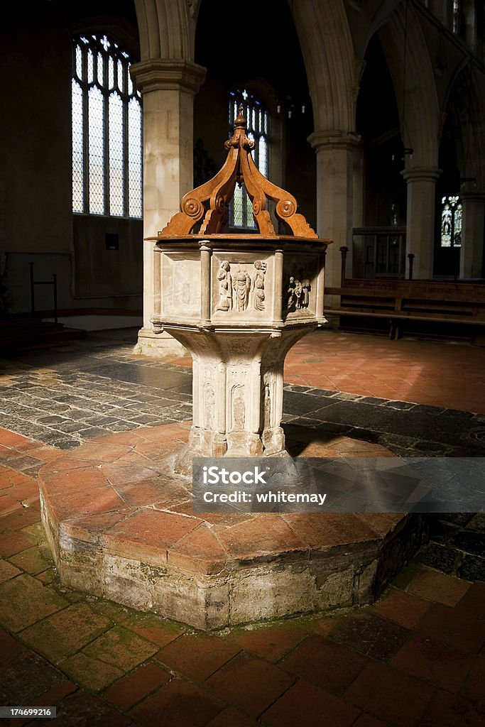 Covered font in a sunbeam A fine example of a rare Seven Sacrament font in the parish church of St Margaret of Antioch at Cley next the Sea, Norfolk. A sunbeam is flooding one face of the font with light. Arch - Architectural Feature Stock Photo