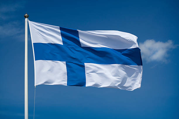 Hoisted Finnish flag with a blue sky background stock photo