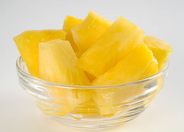 A glass bowl full of pineapple chunks freshly cut.
