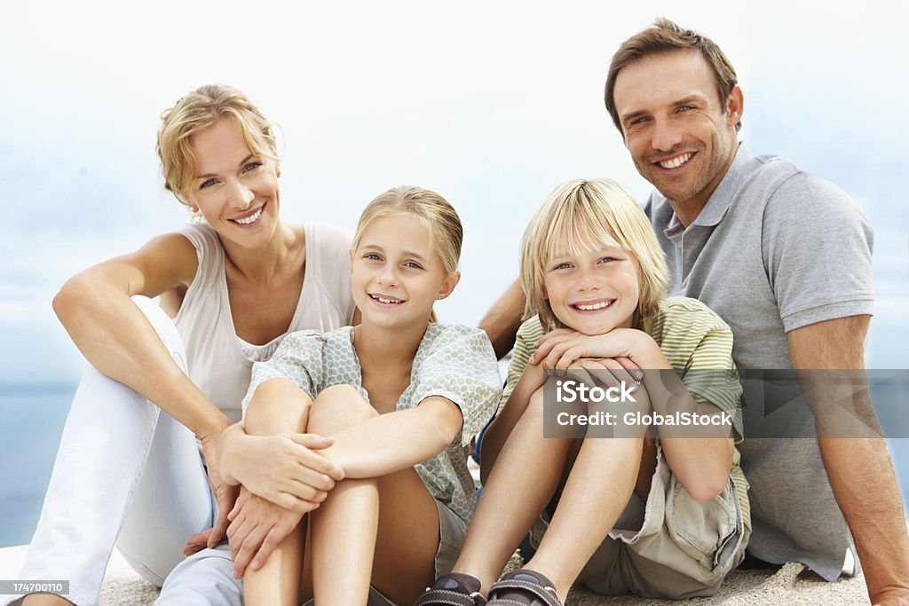 Heureux jeunes parents assis avec des enfants - Photo de Famille libre de droits