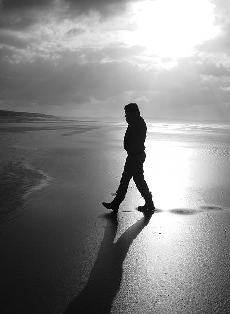 istock silhouette of man walking on beach 174700234