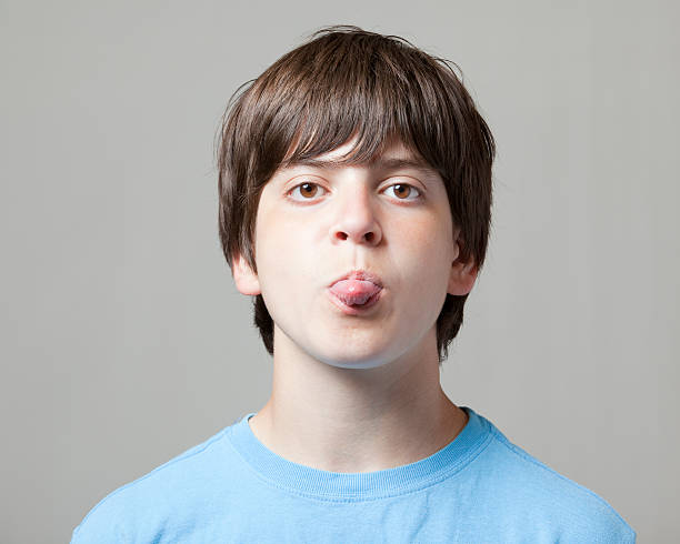 istock boy sticks toungue out at camera 174700842