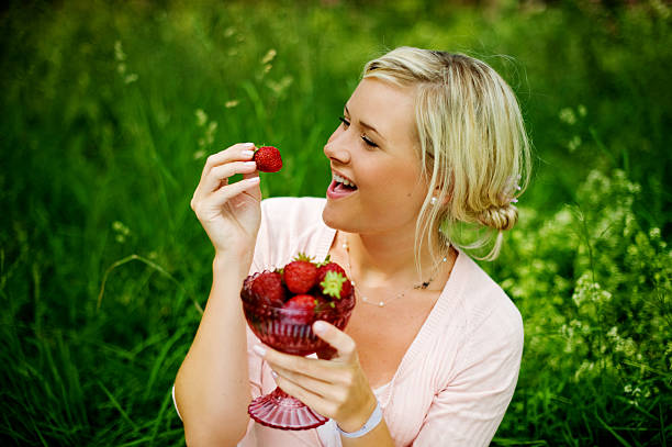 istock woman eating strawberries 174700912