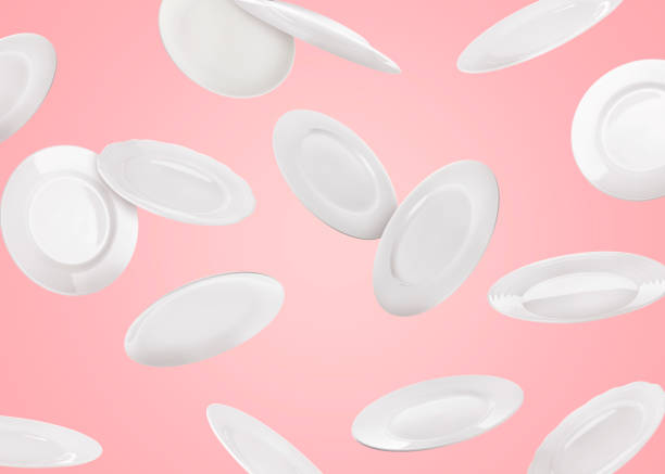 istock Many white plates falling on pastel pink background 1747011685