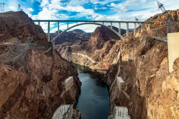 Photo of Mike O'Callaghan-Pat Tillman Memorial Bridge, beside the Hoover Dam across the course of the Colorado River, in the United States of America in the states of Arizona and Nevada under a blue sky.