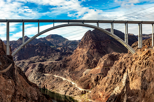 Mike O'Callaghan-Pat Tillman Memorial Bridge, beside the Hoover Dam on the course of the Colorado River in the USA in the states of Arizona and Nevada under a warm blue sky.