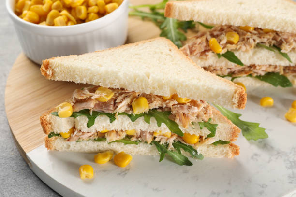 istock Delicious sandwiches with tuna, corn and greens on light grey table 1747016413