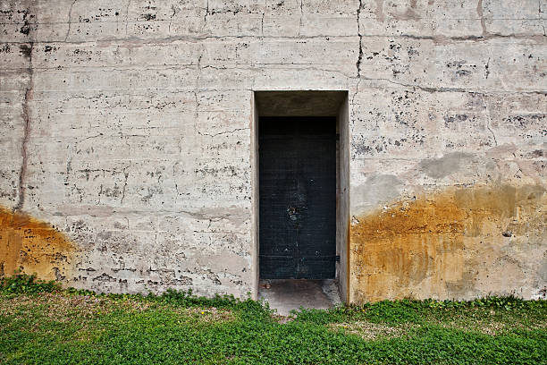 istock Mysterious Black Door in Stained Grungy Concrete Wall 174702145