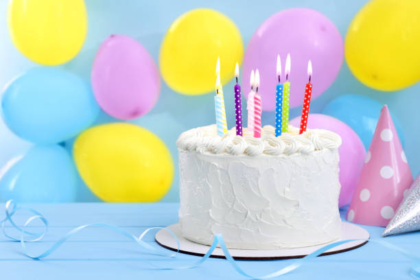 istock Delicious cake with burning candles and festive decor on light blue background. Space for text 1747026897