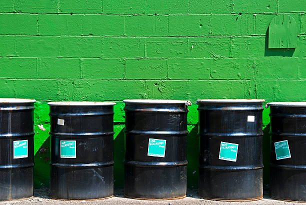 Non-hazardous waste containers by green painted wall at former gas station