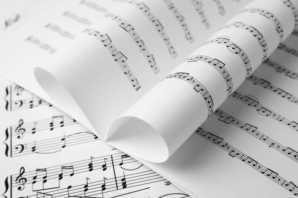 istock Sheets of paper with music notes as background, closeup 1747049323