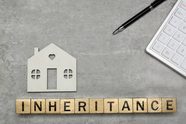 istock Word Inheritance made with cubes, house model and pen on light gray table, flat lay 1747051018