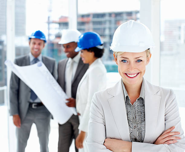 istock Female architect smiling with colleagues planning in the background 174705598