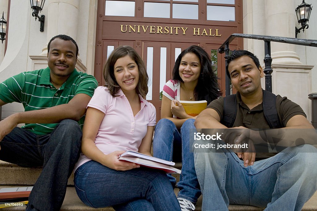 Gruppo eterogeneo di College amici seduto - Foto stock royalty-free di Abbigliamento casual